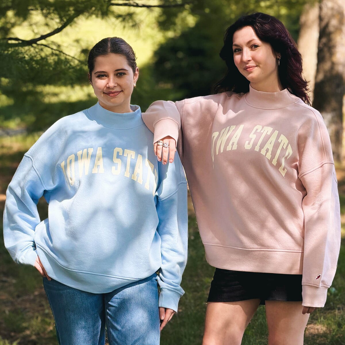 A student wearing League Women's Iowa State Dusty Pink Mock Neck Crew Sweatshirt with another student wearing the matching blue version